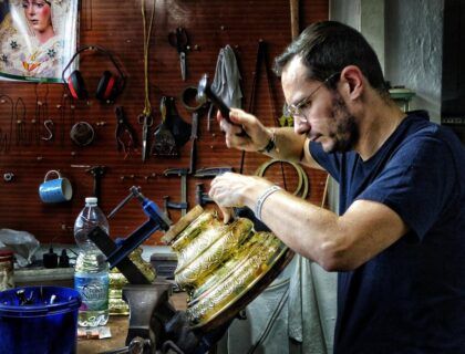 Un joven cincela una pieza del taller de Paula Orfebres en Lucena