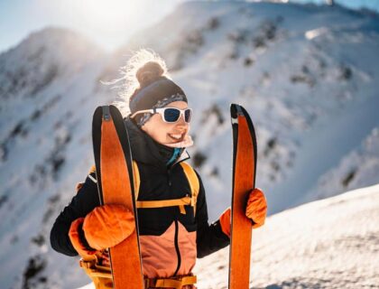 mujer con esquies y mono naranja